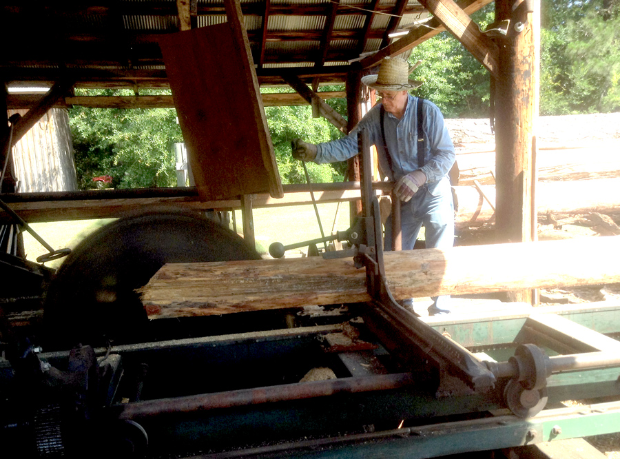 Docent cutting timber at the sawmill at georgia agrirama