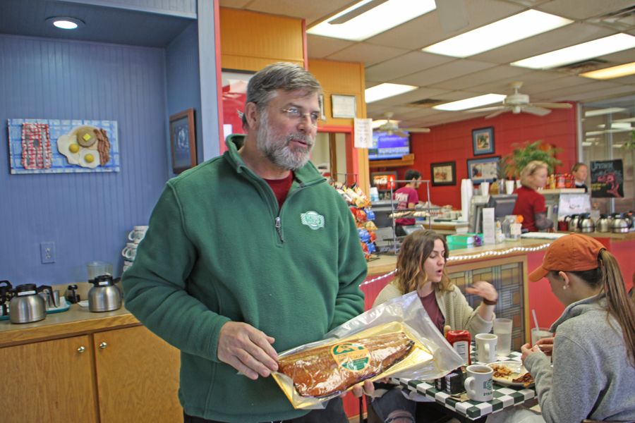 owner at Uptown Cafe showing guests a salmon in Tallahassee, FL