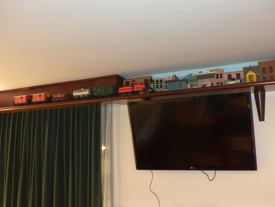 model train runs around just under ceiling in room at Dinah's Garden Hotel