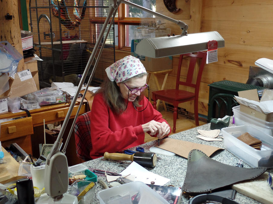 woman working leather at The Raven’s Niche and Mykytka Leather in bolder Junction, wisconsin