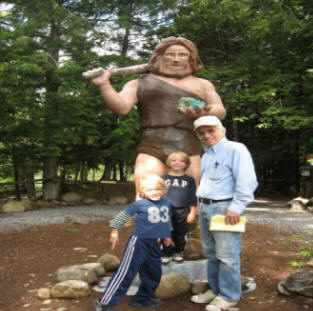 Family poses at cave man stature at Natural Stone Bridge and Caves in Pottersville, New York