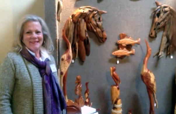 Pat Warren displays several of Marlin Miller's woodcarvings at Gallery on the Row