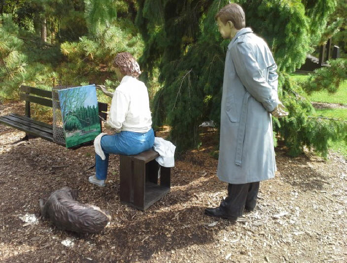 sculpture of plein air painter wtht spectator looking over her shoulder at Grounds for Sculpture near Trenton, N.J.