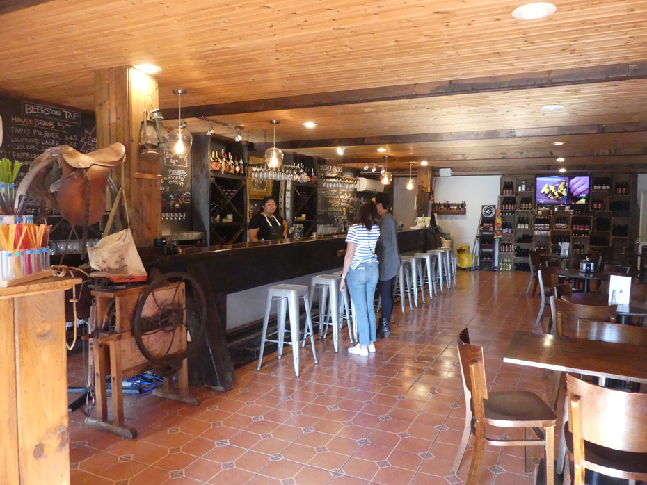 Inside pub at Becker Farms couple at counter wiht woman behnd bar.