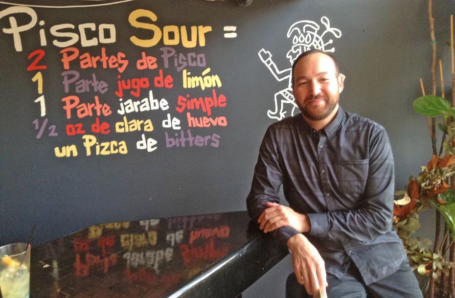 Eric Canupp poses in front of a recip board for one of La Costenera's specialty cocktails