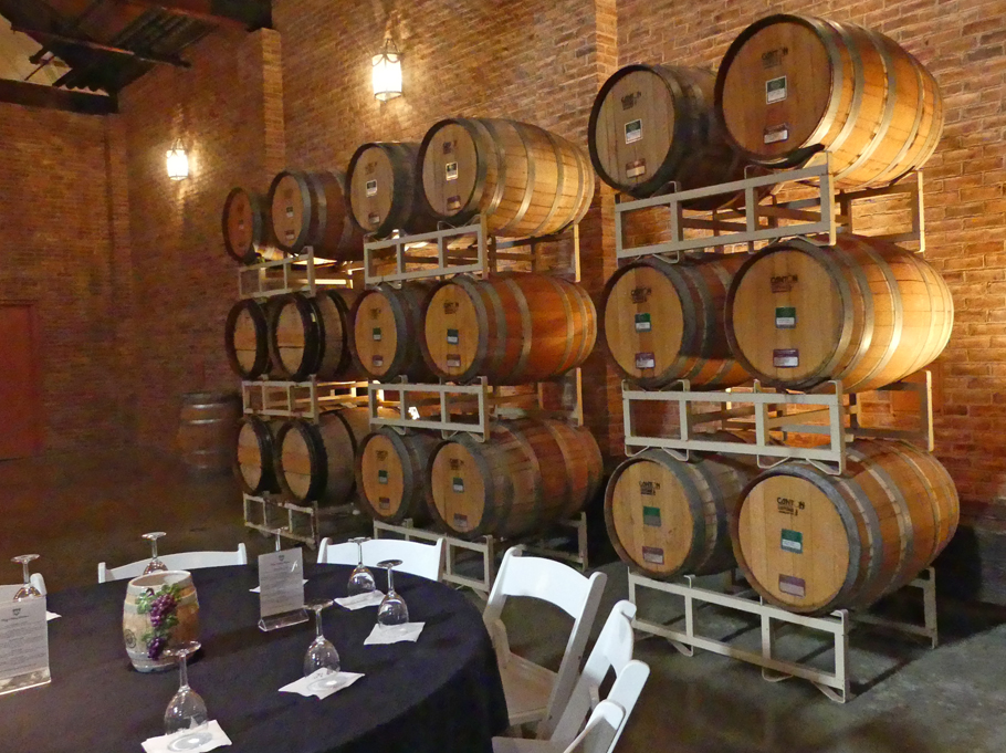 table set wth wine glasses and barrels in back  at Delaney Winery and Vineyards