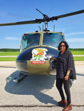 Woman standing n front of Huey Heliocopter