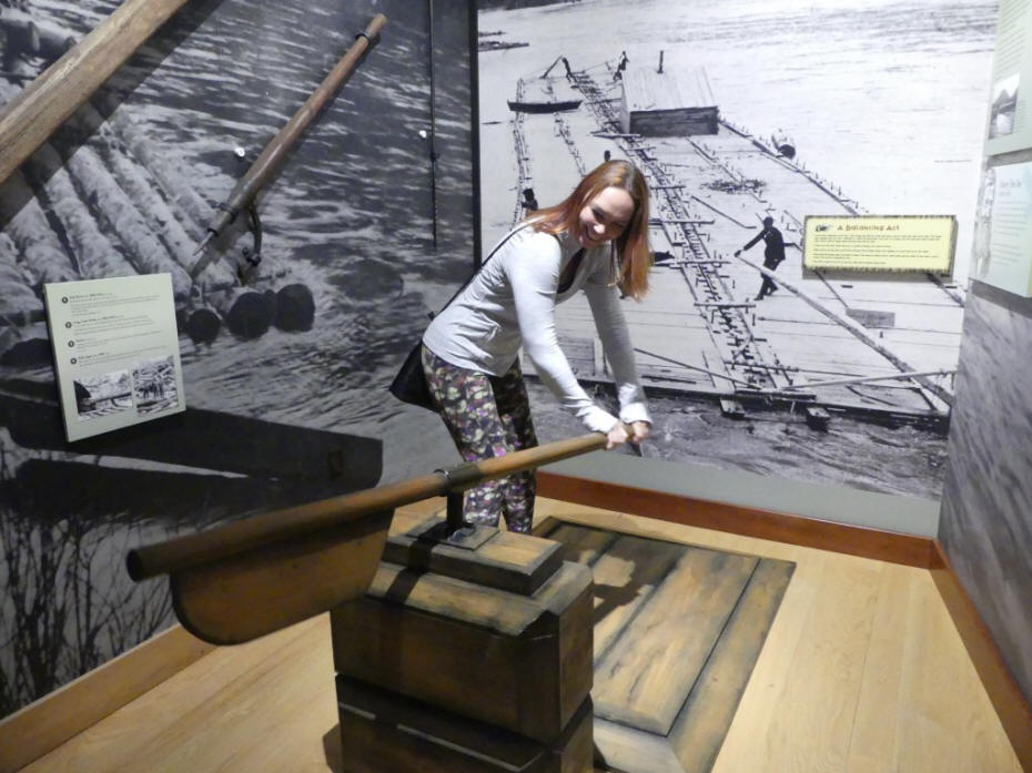 friend steering a raft at interactive exhibit at lumber museum