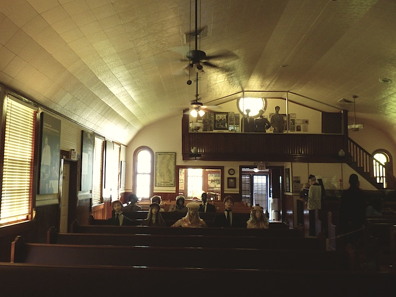  a church interior with worshipers deptricted at Historic Riverlands Christian Center